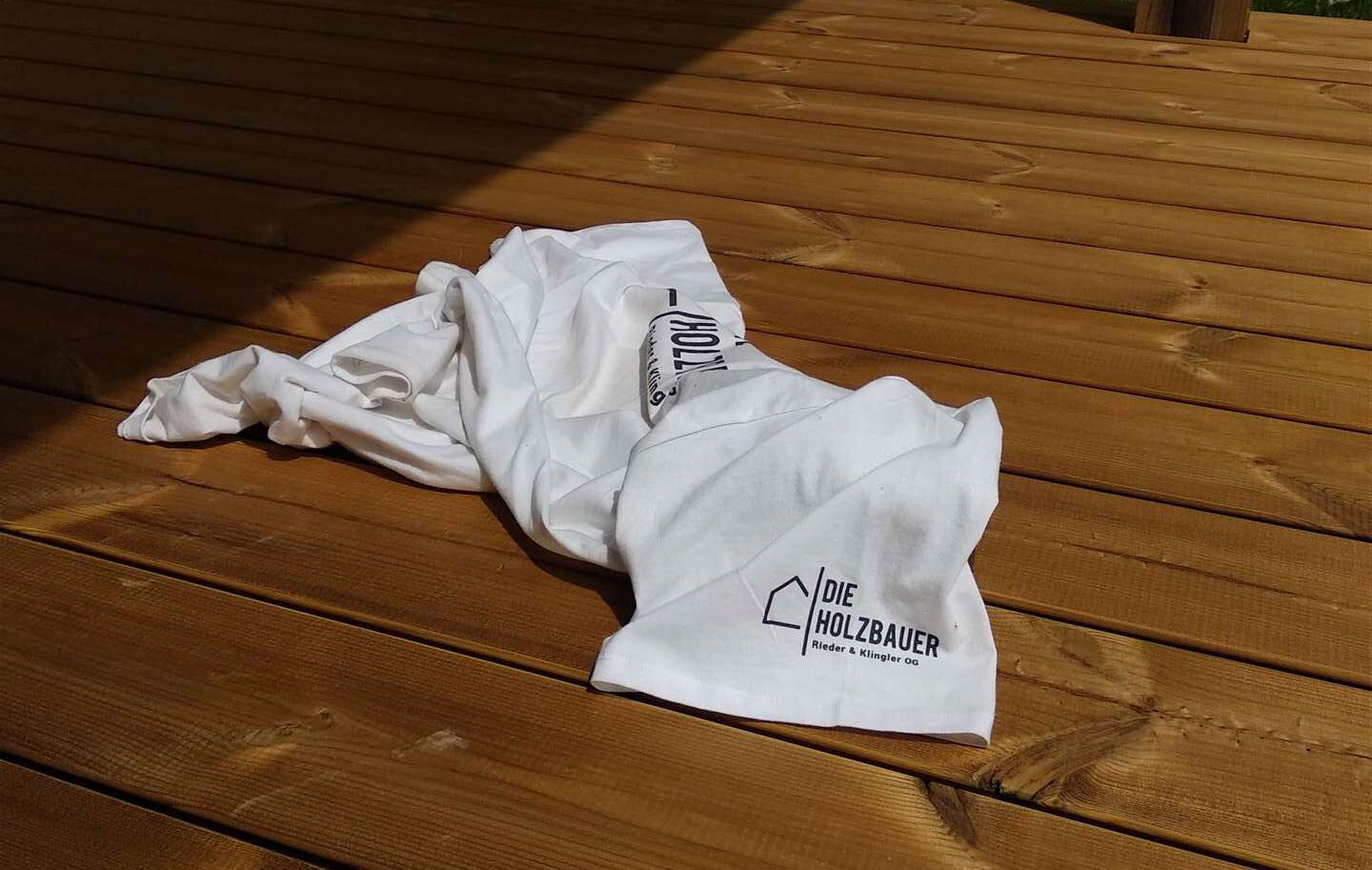 T-Shirt mit Logo auf Holzboden